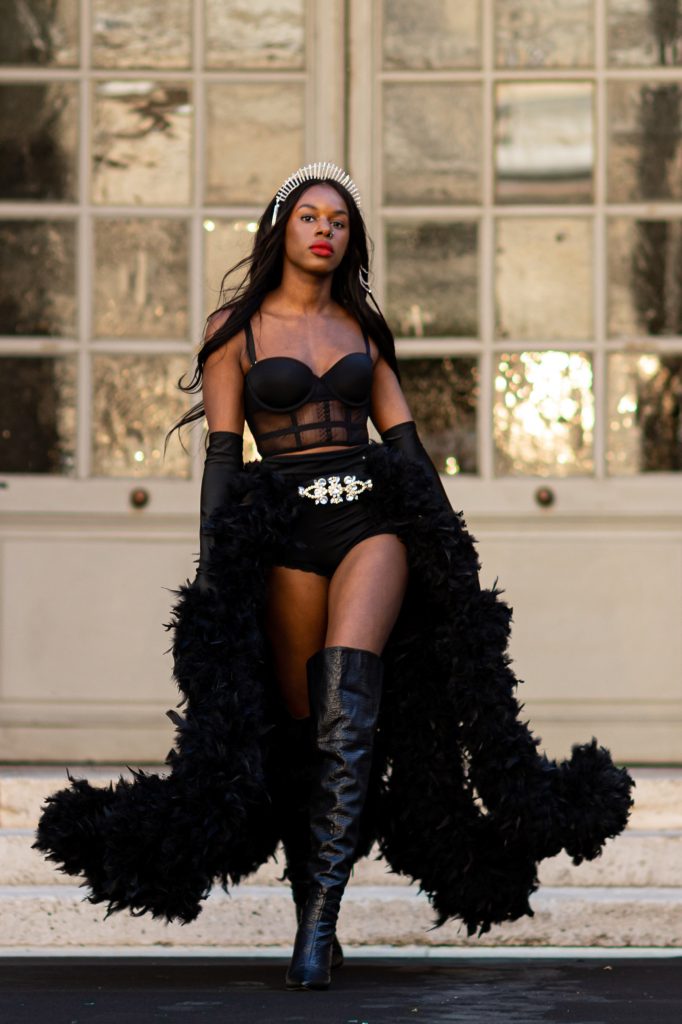 mannequin portant un body noir et une jupe en plumes